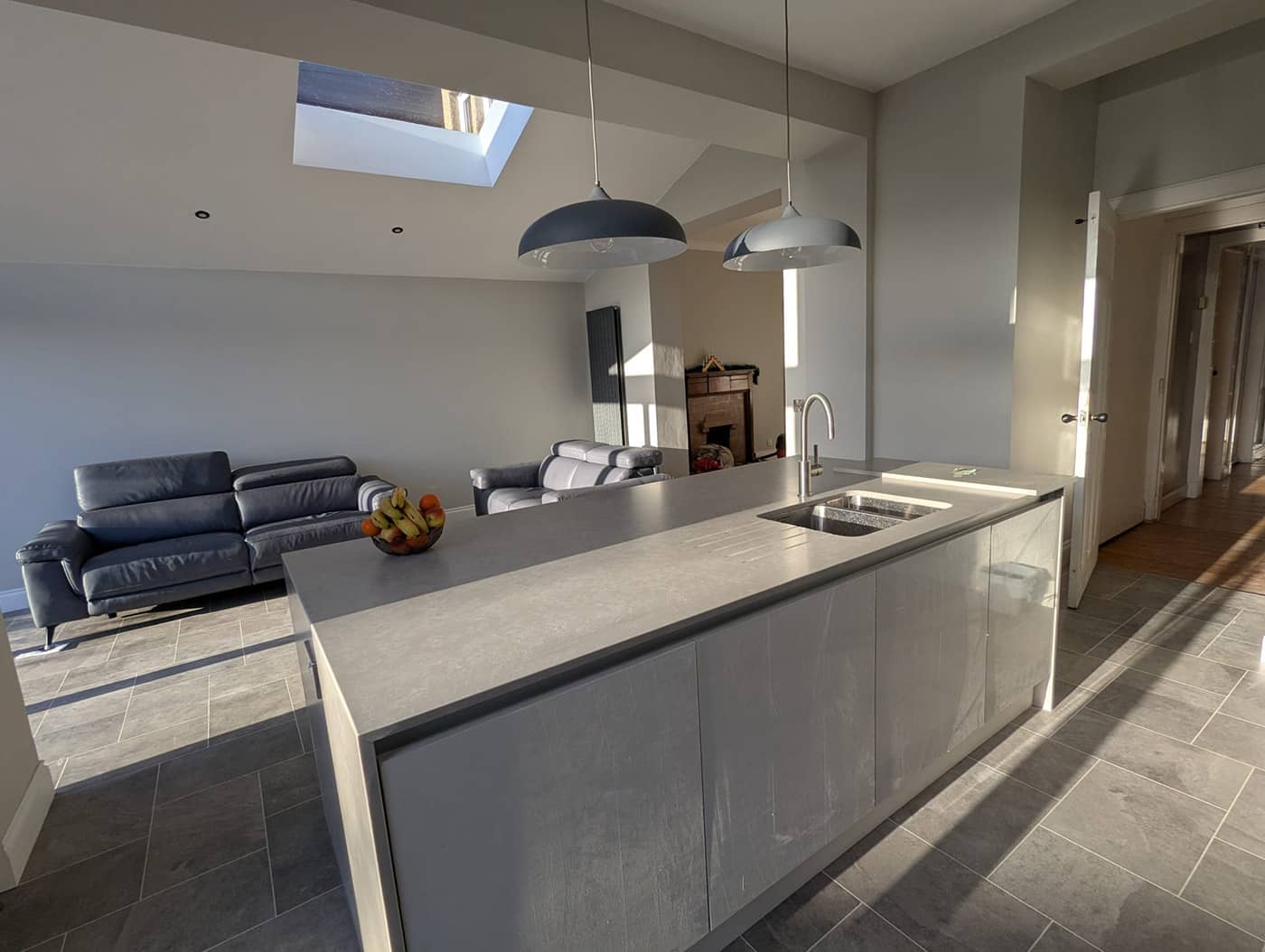 Kitchen island in the completed extension, with a roof light above and an opening through to the original house